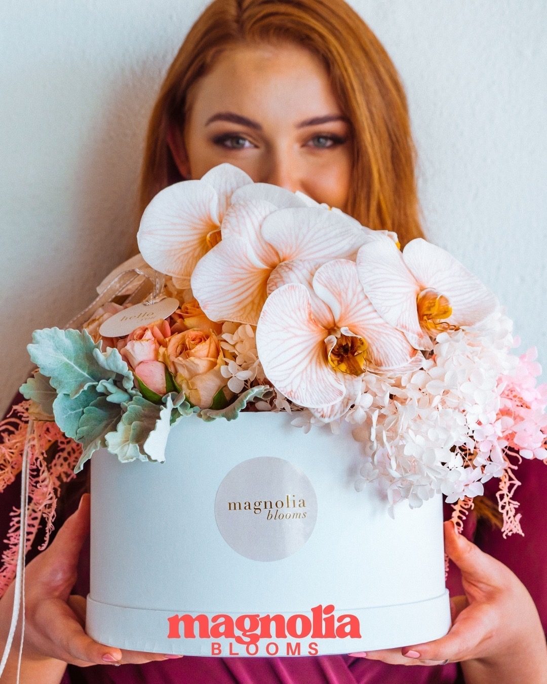 A Magnolia Blooms hat box filled with orchids and preserved blooms